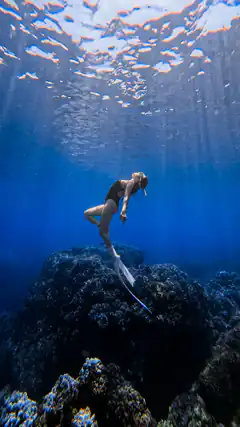 woman freediving underwater with long fins