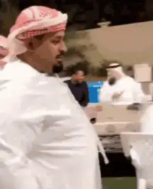 Two men in thobes bump bellies