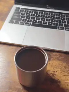 coffee cup in front of laptop