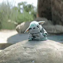 Baby Yoda falls asleep on a rock