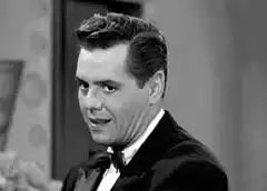 Man in tuxedo reacts with shock