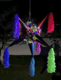 Colorful star piñata hanging at night