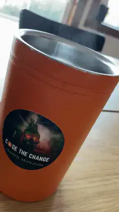 Orange tumbler with Code the Change sticker