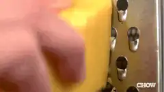 Hand grating yellow cheese on metal grater