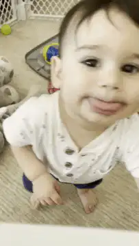 Baby sticking tongue out and reaching for camera