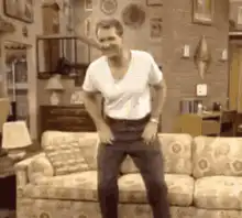 man falls onto couch laughing