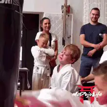 Crying boy punches bag while another boy watches
