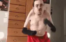 shirtless man in red shorts boxing