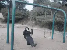 person in plague doctor mask on swing
