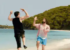 Two men jumping on a beach
