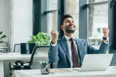 Businessman celebrating success at desk