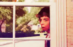 Woman looking out window shocked