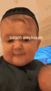 Baby in kufi smiling and looking down