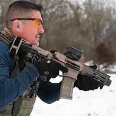 man aiming rifle in snow