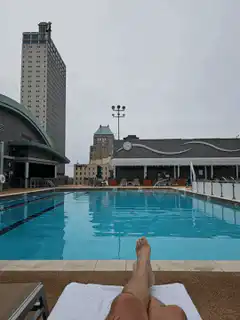 First person view relaxing by a rooftop pool