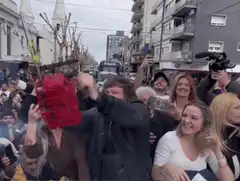 Man swings red backpack at crowd