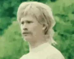 Blonde man with mustache looking around