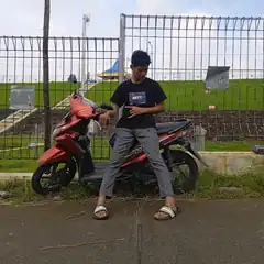 man posing with red scooter