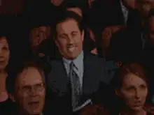 Man raises hands and bows head in audience