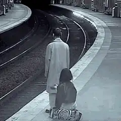 Girl draws on man's coat at train station