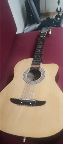 acoustic guitar on red couch