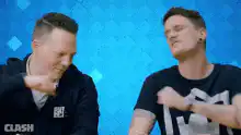 Two men fist bump with fire and smoke