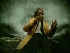 Man in yellow jacket looking up at sky