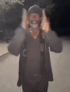 Man dancing and pointing at night