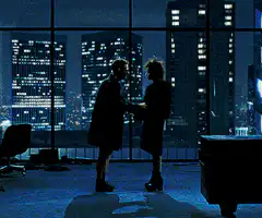 Two people holding hands in front of city lights