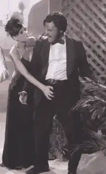 Man puts on sunglasses while woman holds his crotch