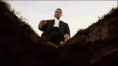 Man throwing dirt into grave