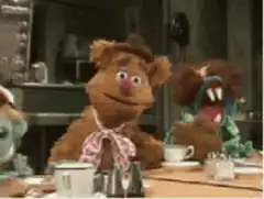 Fozzie Bear laughs at the table