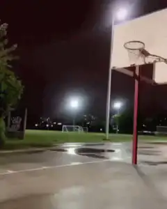Person dunking basketball at night
