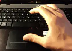 hand on laptop keyboard and touchpad