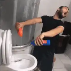 man cleaning bathroom and holding dog