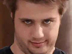 Man smirking with intense blue eyes