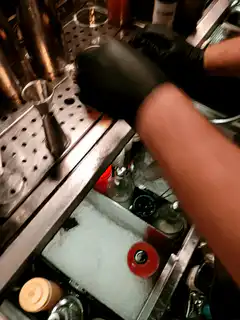bartender garnishes cocktail with orange slice