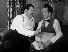 Two men shaking hands and laughing