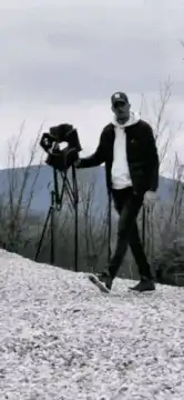 man carries chair then sits