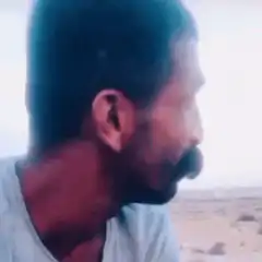 Man with mustache turns and laughs