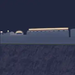 Red train drives past snowy buildings at night