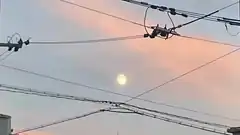 drone stuck in power lines at sunset