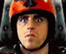 Man in orange helmet wide-eyed