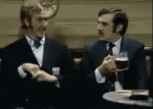 Two men in suits talking in a pub