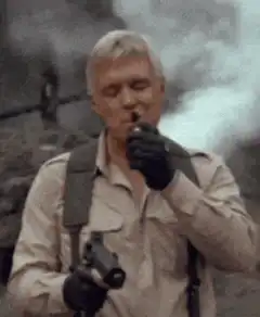 Man smoking while explosion happens behind him
