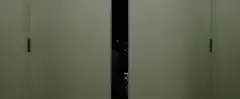Two men peeking through elevator doors