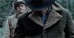 Two cowboys hugging in the woods