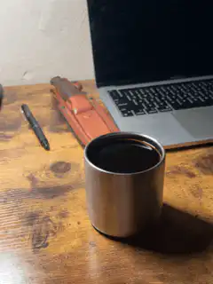 coffee cup on desk with laptop