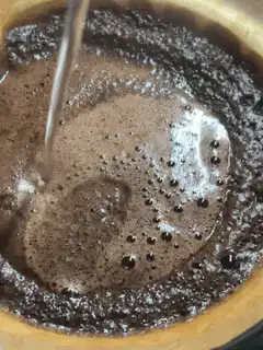 Pouring water into coffee grounds
