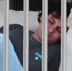 Man sleeping behind bars